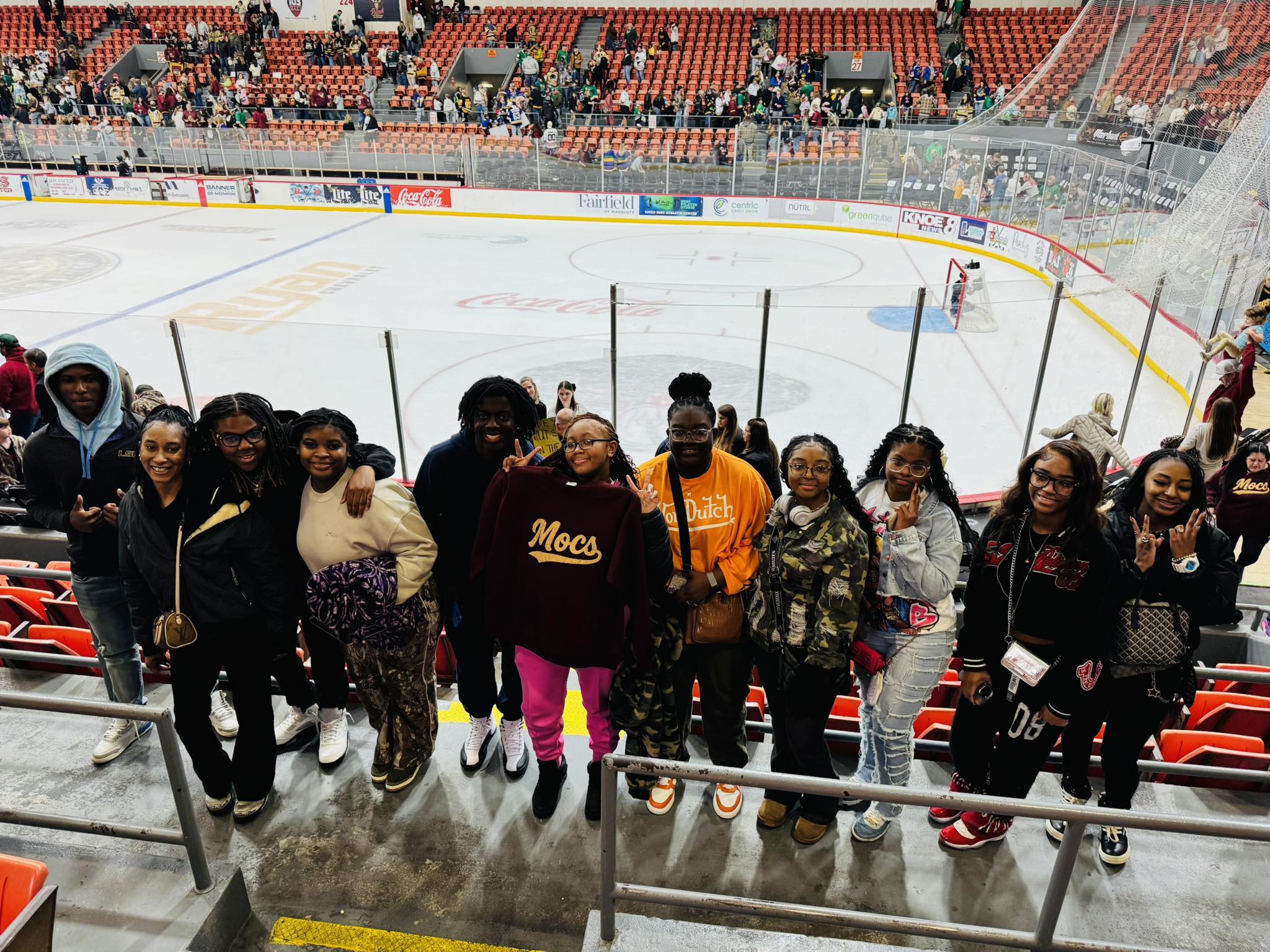 A group of teenagers at a hockey rink.